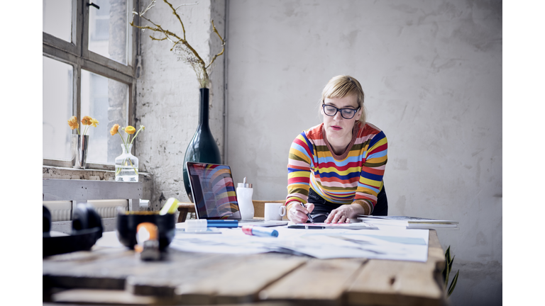 Portrait of woman working at desk in a loft