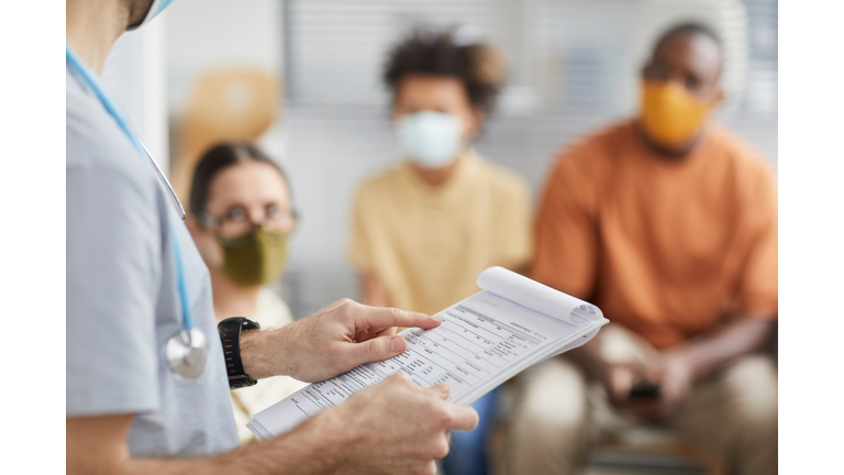 Male Nurse Checking Vaccination Chart