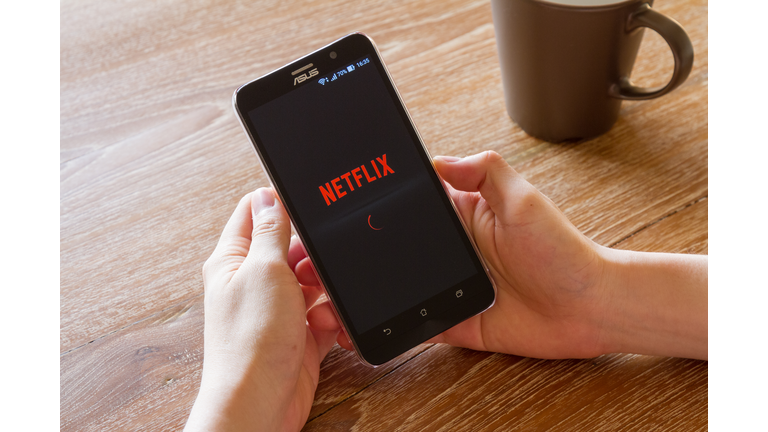 man hand holding screen shot of Netflix application