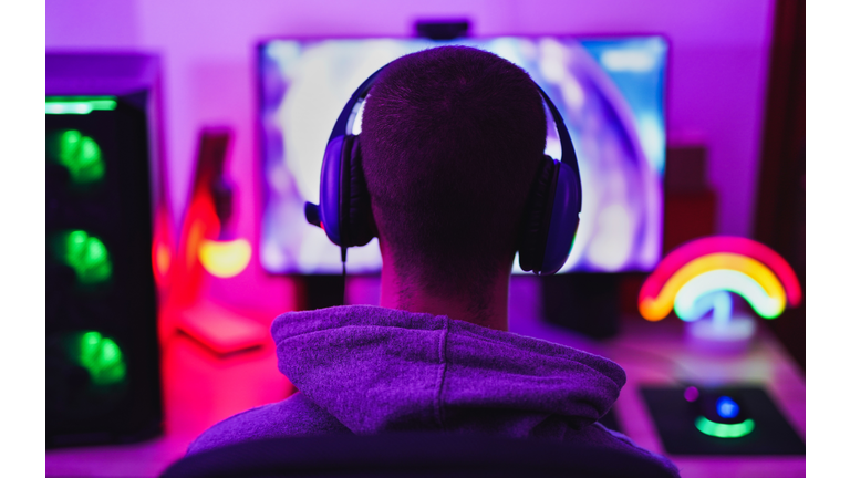 Young man wearing headset and play computer video games online - Home isolated for coronavirus