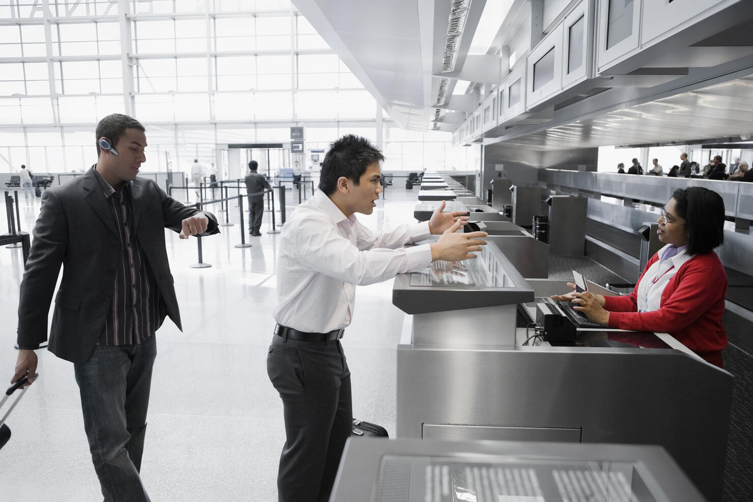 Businessman shouting at an airline check-in attendant