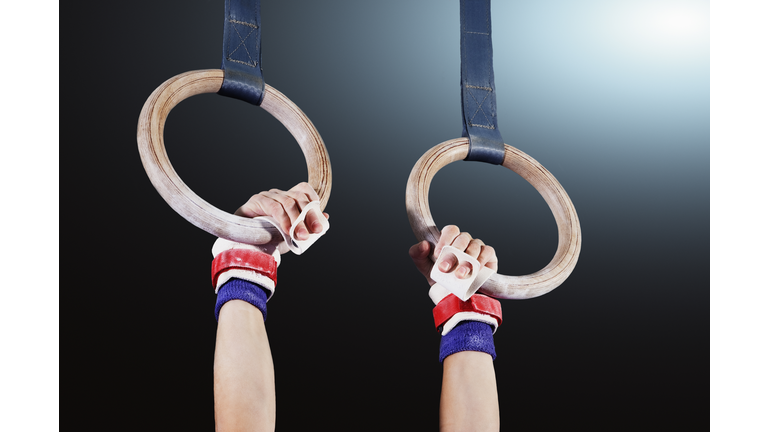 Young gymnast hanging from rings