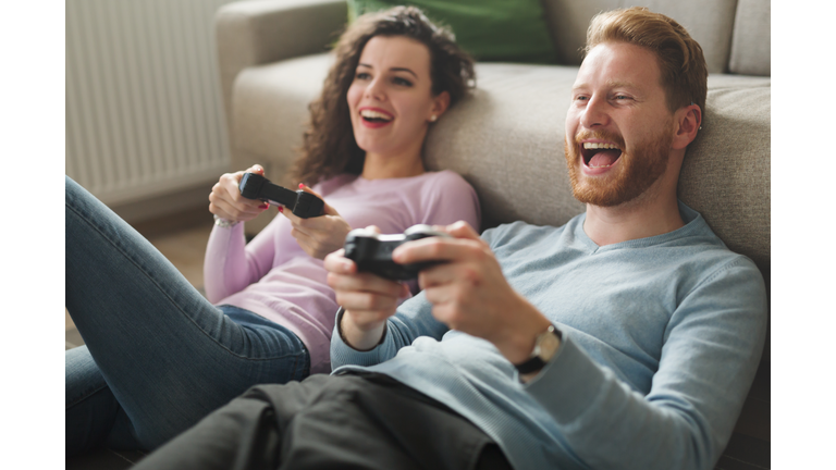 Beautiful couple playing video games on console