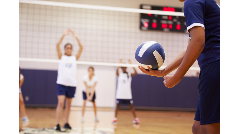 High School Volleyball Match In Gymnasium