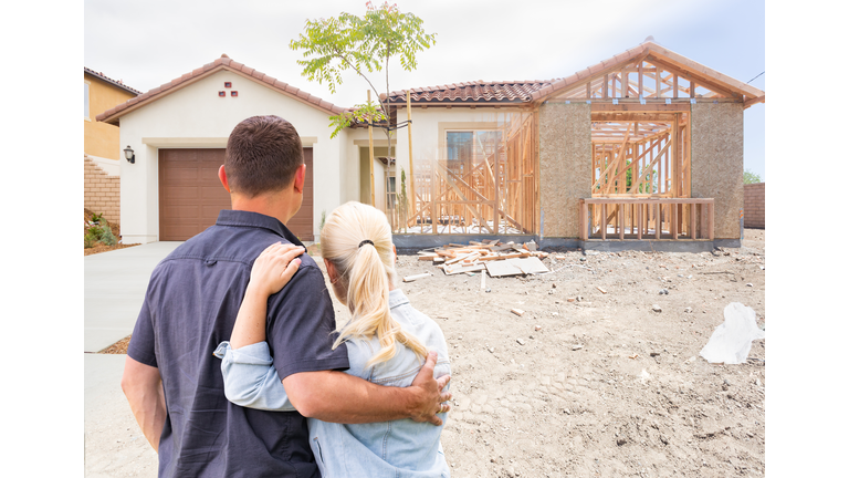 Couple Facing Construction Framing Gradating To Completed Home