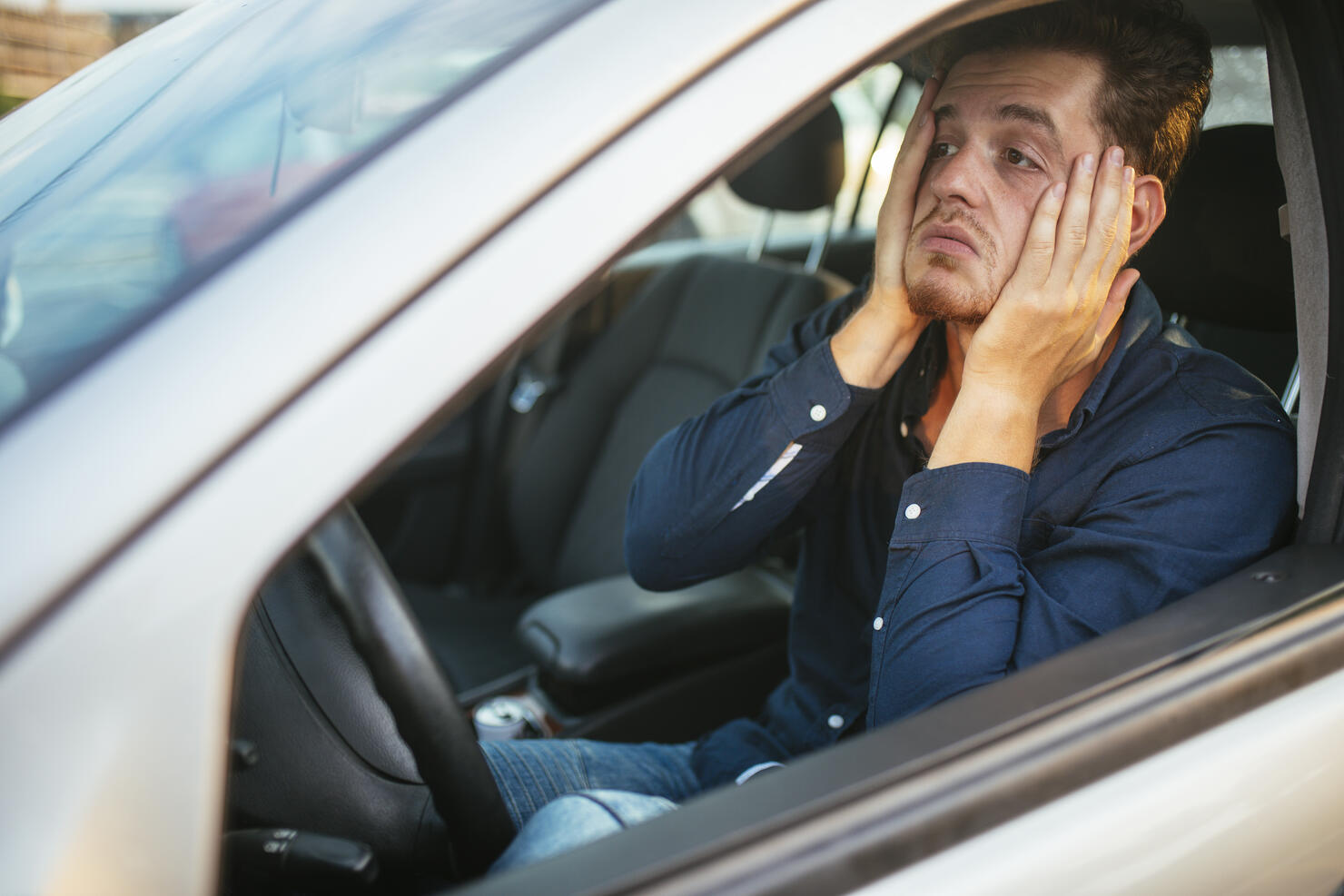 A young man desperately waits in the traffic jam