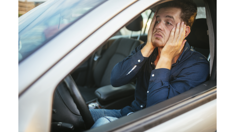 A young man desperately waits in the traffic jam