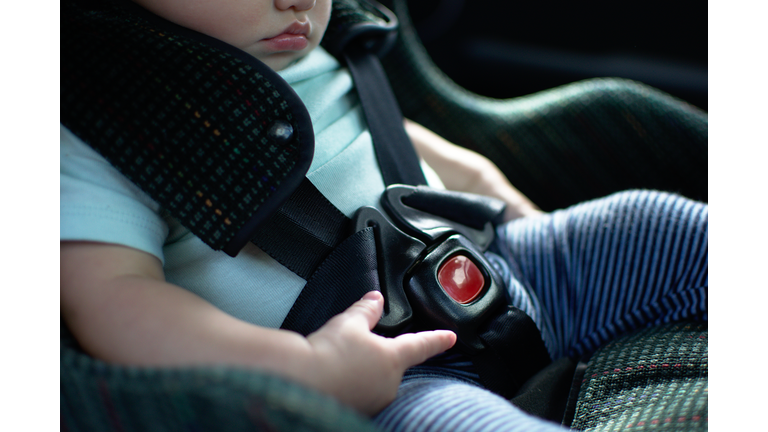 Baby in rear facing car seat  has the safety belt on