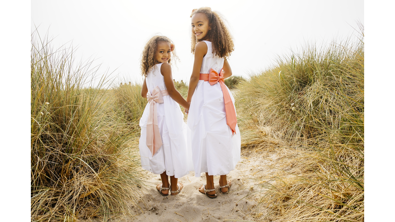 Mixed race sisters walking on beach