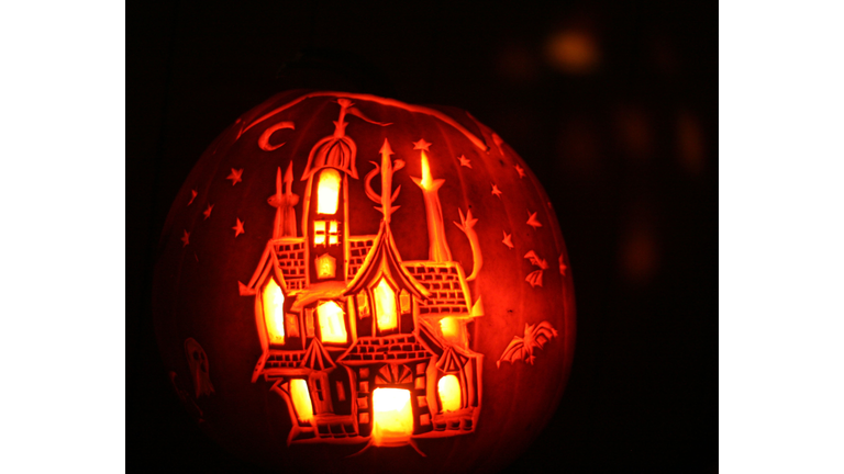 Carved pumpkin with haunted house