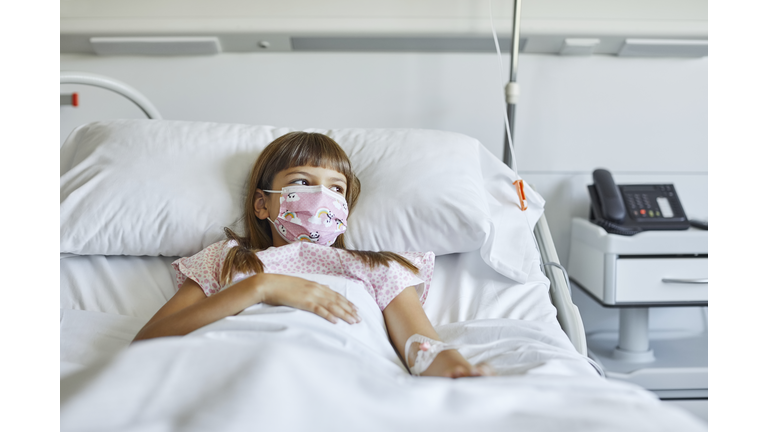 Sick girl lying on bed in ICU during COVID-19