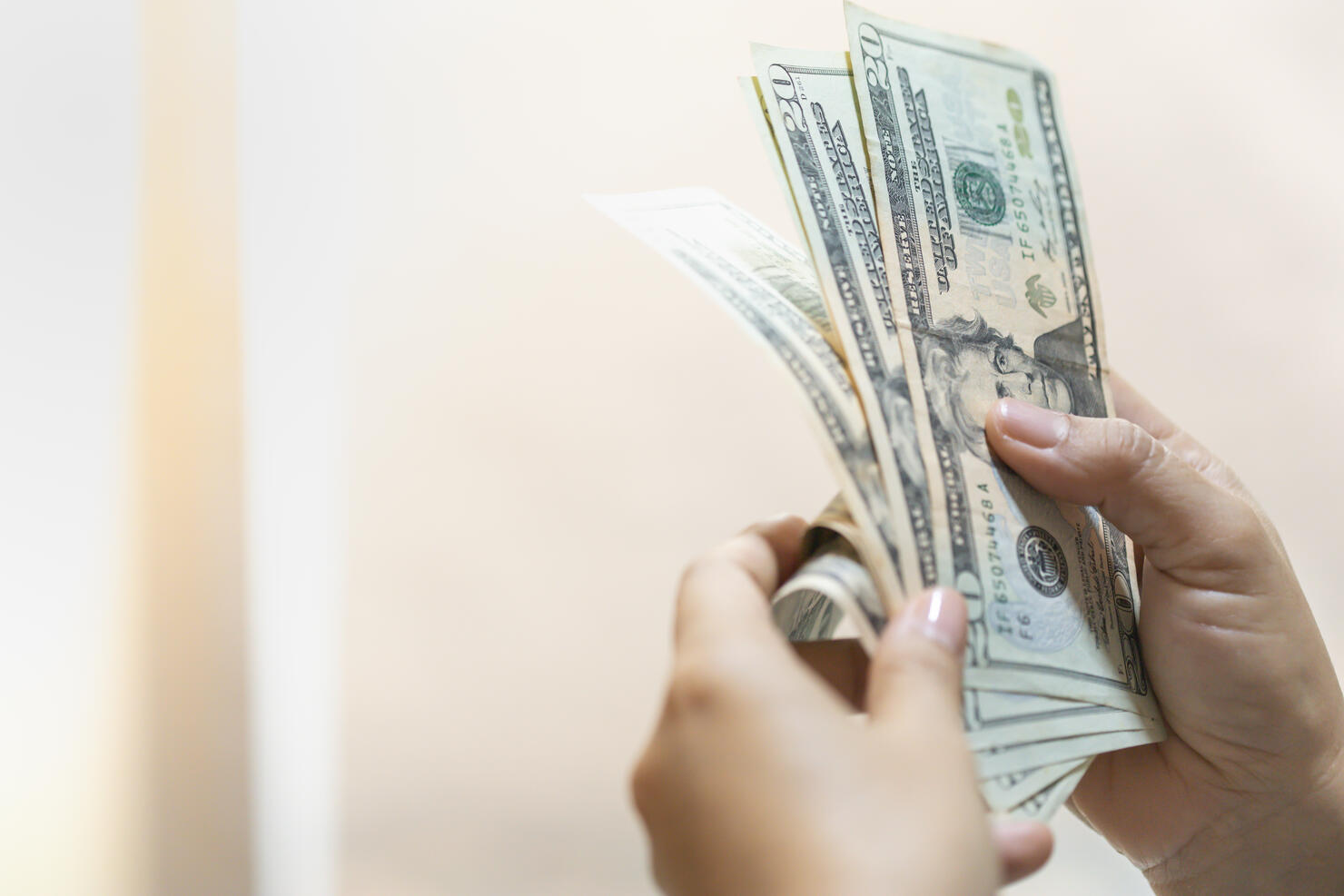 Money Business shopping and saving concept. Close up of woman hand holding and counting US Dollar banknote with copy space.