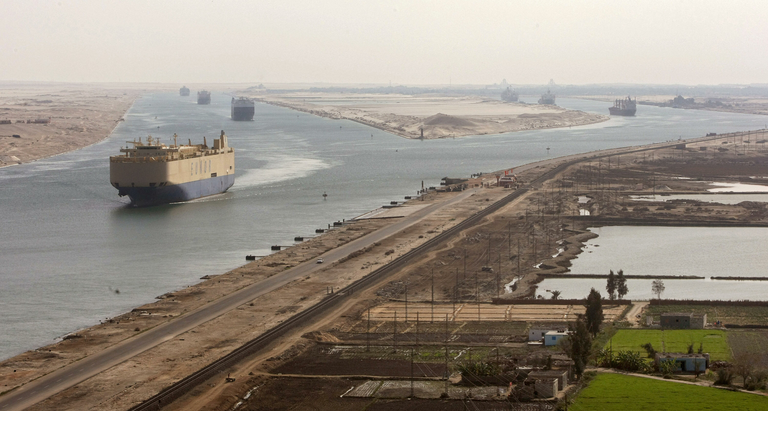 Cargo ships navigate in the Suez Canal b