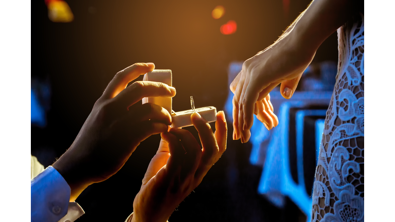 Man open a ring box to give a gift to his girlfriend.