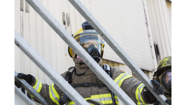 Female firefighter in protective gear and oxygen mask