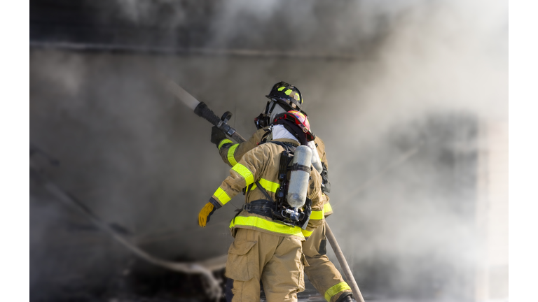 Two firefighters at work putting out a fire