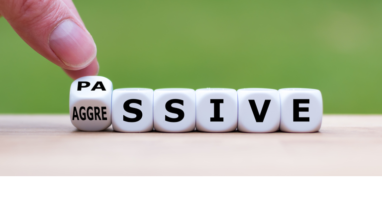 Hand turns a dice and changes the word "passive" to "aggressive", or vice versa.