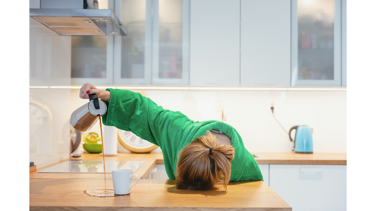 Tired Woman Trying To Drink Morning Coffee And Sleeping On The Table