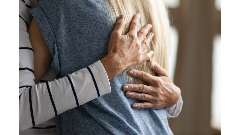 Close up cropped image elderly mother hugs grownup daughter