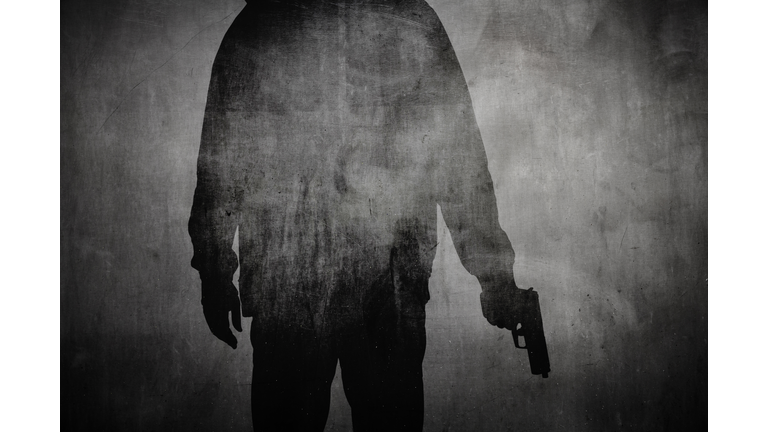 Silhouette of a man holding a gun