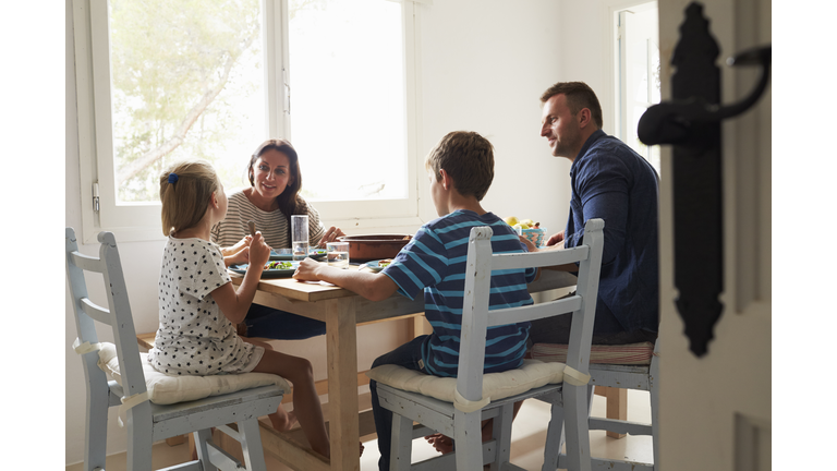 Family At Home In Eating Meal Together