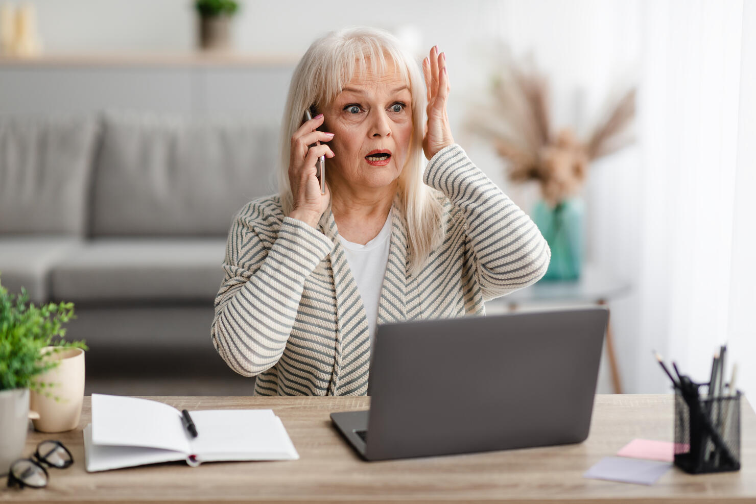 Surprised shocked mature woman talking on mobile phone