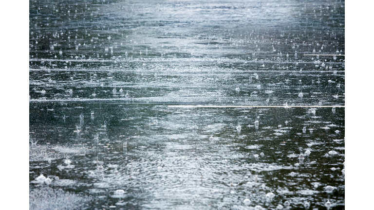 flooded road during heavy rain with raindrops splashes