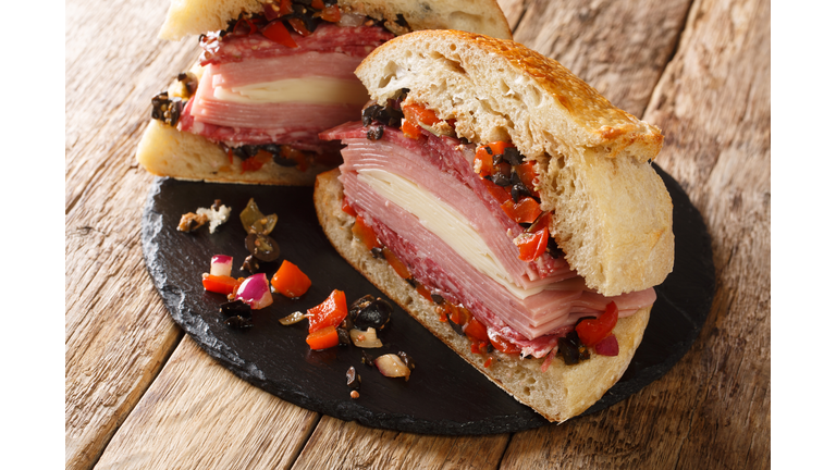 Cajun Muffaletta Sandwich with Meat Olives and Cheese close-up on a slate board. Horizontal