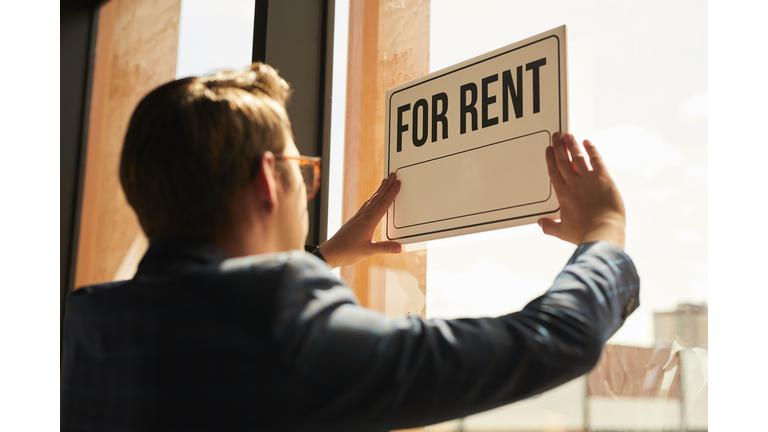 Real Estate Agent hanging For Rent Sign