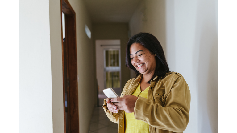 Smiling woman sending text message