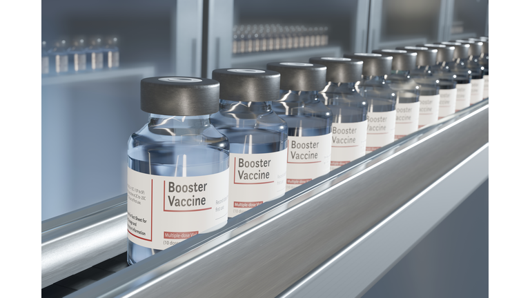 Vials of booster vaccine on conveyor in pharmaceutical factory