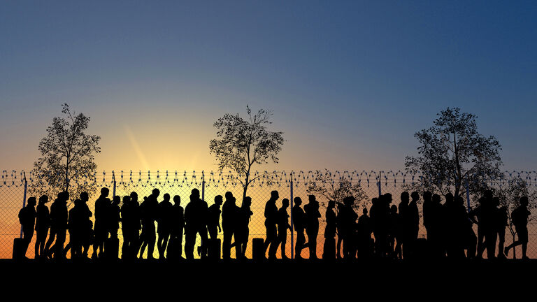 Column of migrants near the state borders. Fence and barbed wire. Surveillance, supervised. Refugees and immigrants