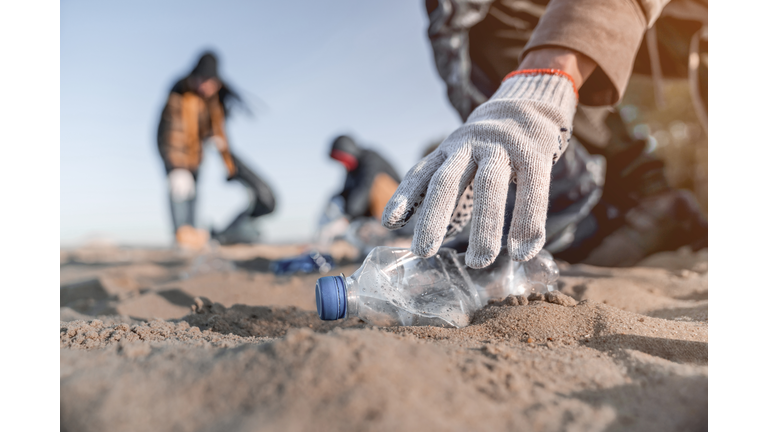 Volunteer man collecting trash on the beach. Ecology concept