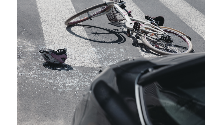 Helmet next to bike on crosswalk after collision with car