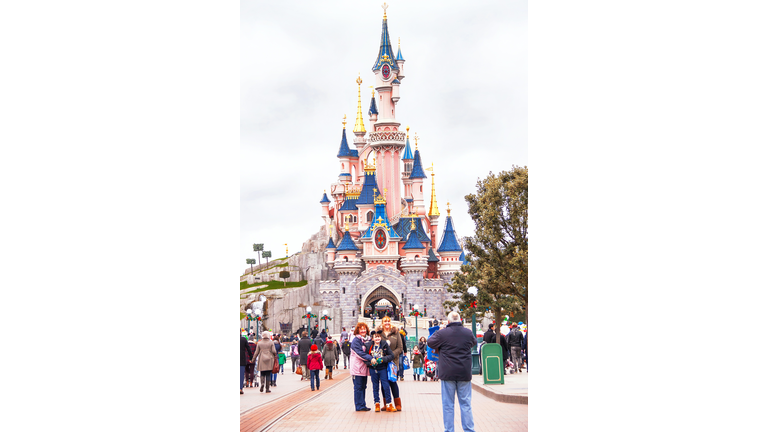 Happy people near castle in the Disneyland Paris.