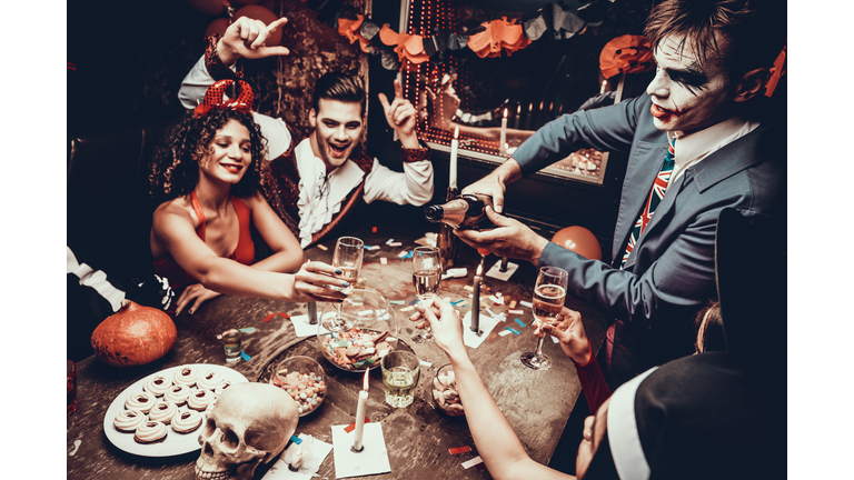 Young People Wearing Costumes Drinking Champagne