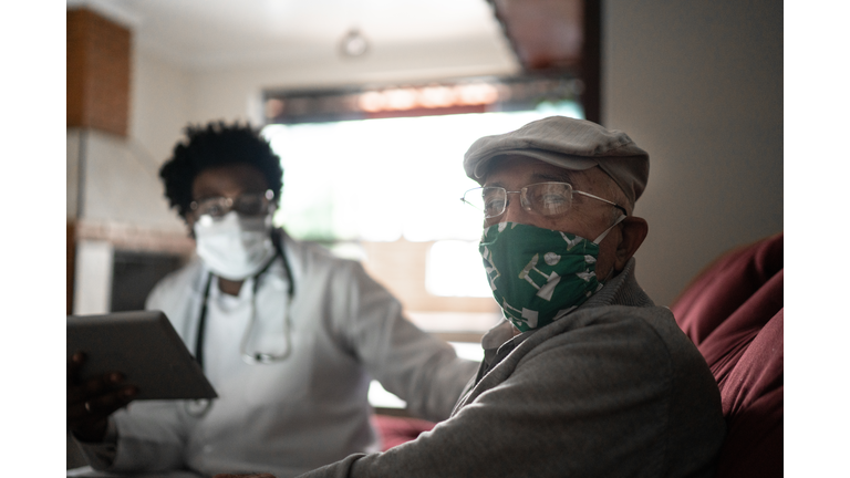 Portrait of senior patient and his doctor at home