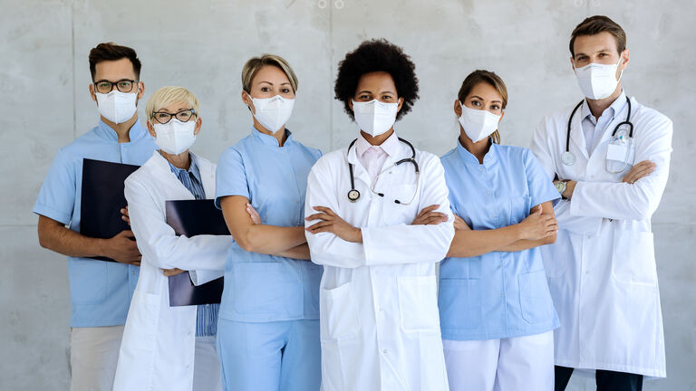 Team of confident medical experts with protective face masks.