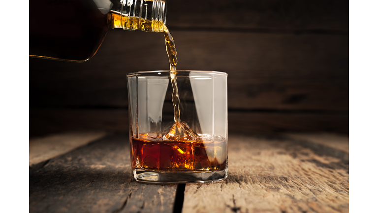 Pouring glass of whiskey, Close-up whisky on the rocks.