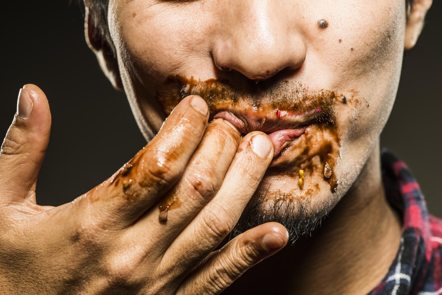 Mid adult man licking chocolate,close up shot