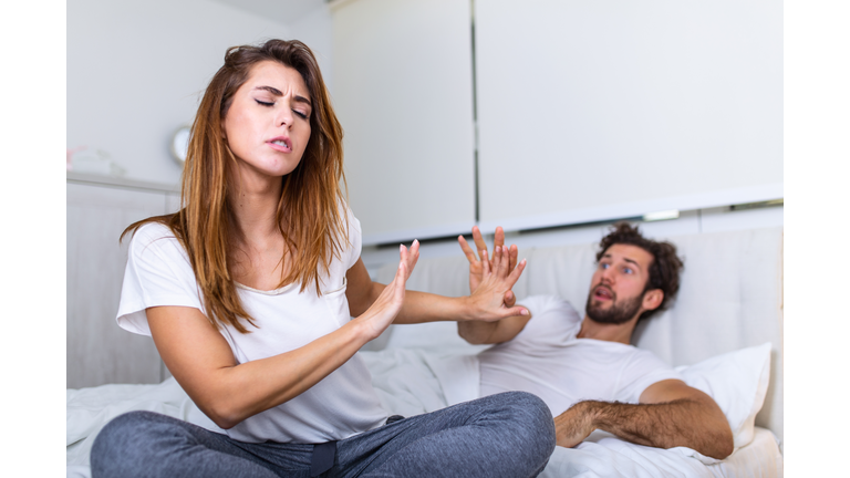 Couple With Problems Having Disagreement In Bed. Frustrated couple arguing and having marriage problems, Young couple into an argument on bed in bedroom