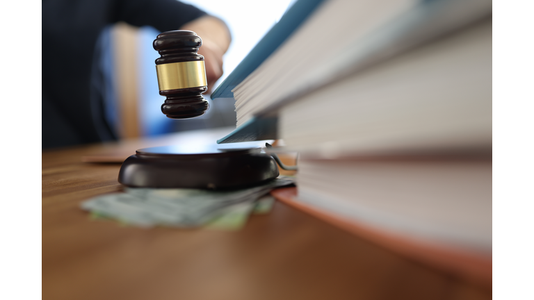 Wooden gavel for judge on table next to folder with documents.