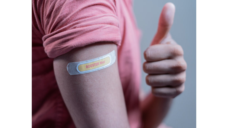 covid-19 or coronavirus vaccinated shoulder with booster shot sticker and thumbs up gesture - concept of approved coronavirus 3rd dose vaccination for immunocompromised.