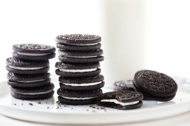 Oreo cookies stacked with milk on white background