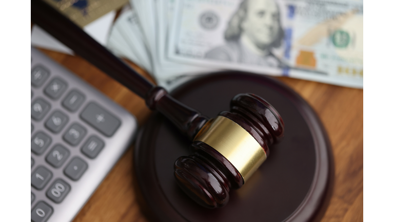 Hammer, american dollars, calculator lie on table in courthouse close-up