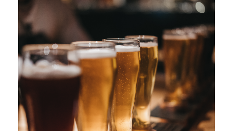 Close up of a rack of different kinds of beers, dark to light, on a table.