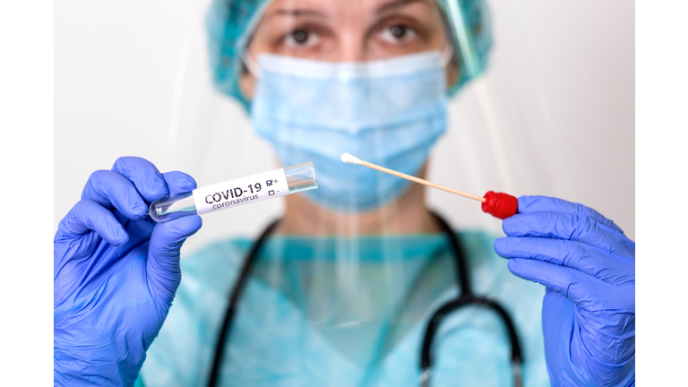 Medical healthcare holding COVID-19 , Coronavirus swab collection kit, wearing PPE protective suit mask gloves, test tube for taking OP NP patient specimen sample,PCR DNA testing protocol process