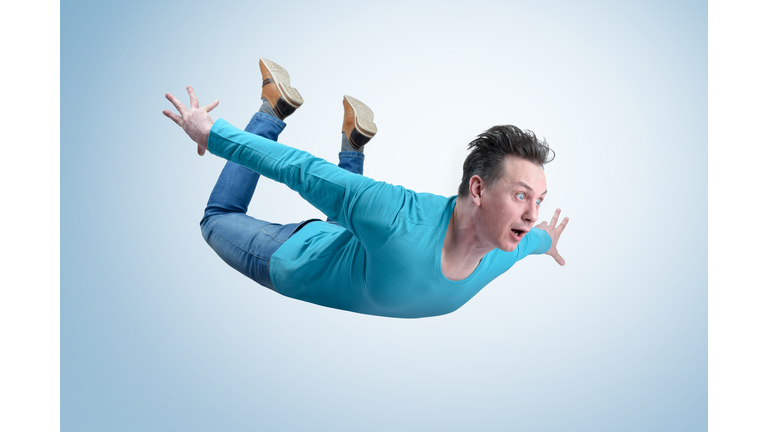 Crazy man in shirt and jeans is flying in the sky. Jumper concept