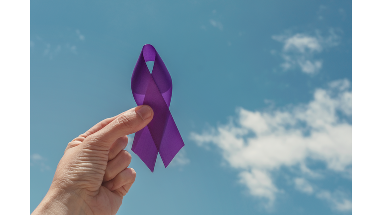 hand holding purple ribbon over blue sky, Alzheimer's disease, Pancreatic cancer, Epilepsy awareness, world cancer day