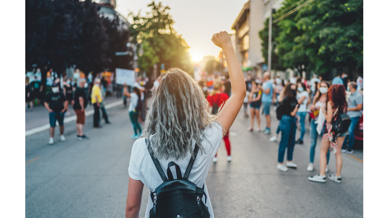 Young woman protester raising her fist up